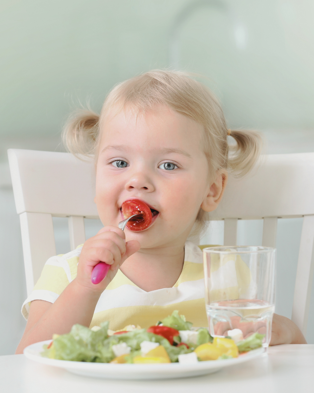 Toddler eating salad and chewing vegetables to support healthy jaw and oral development