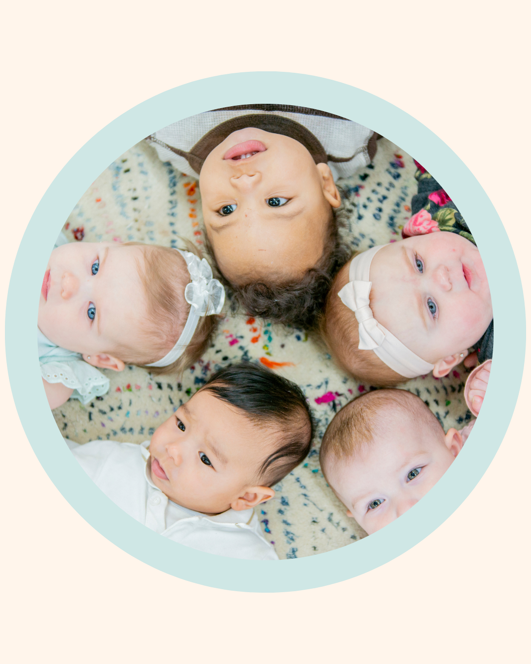 Group of babies lying on a patterned rug, representing infant development and oral ties awareness for parents learning about tongue and lip ties.