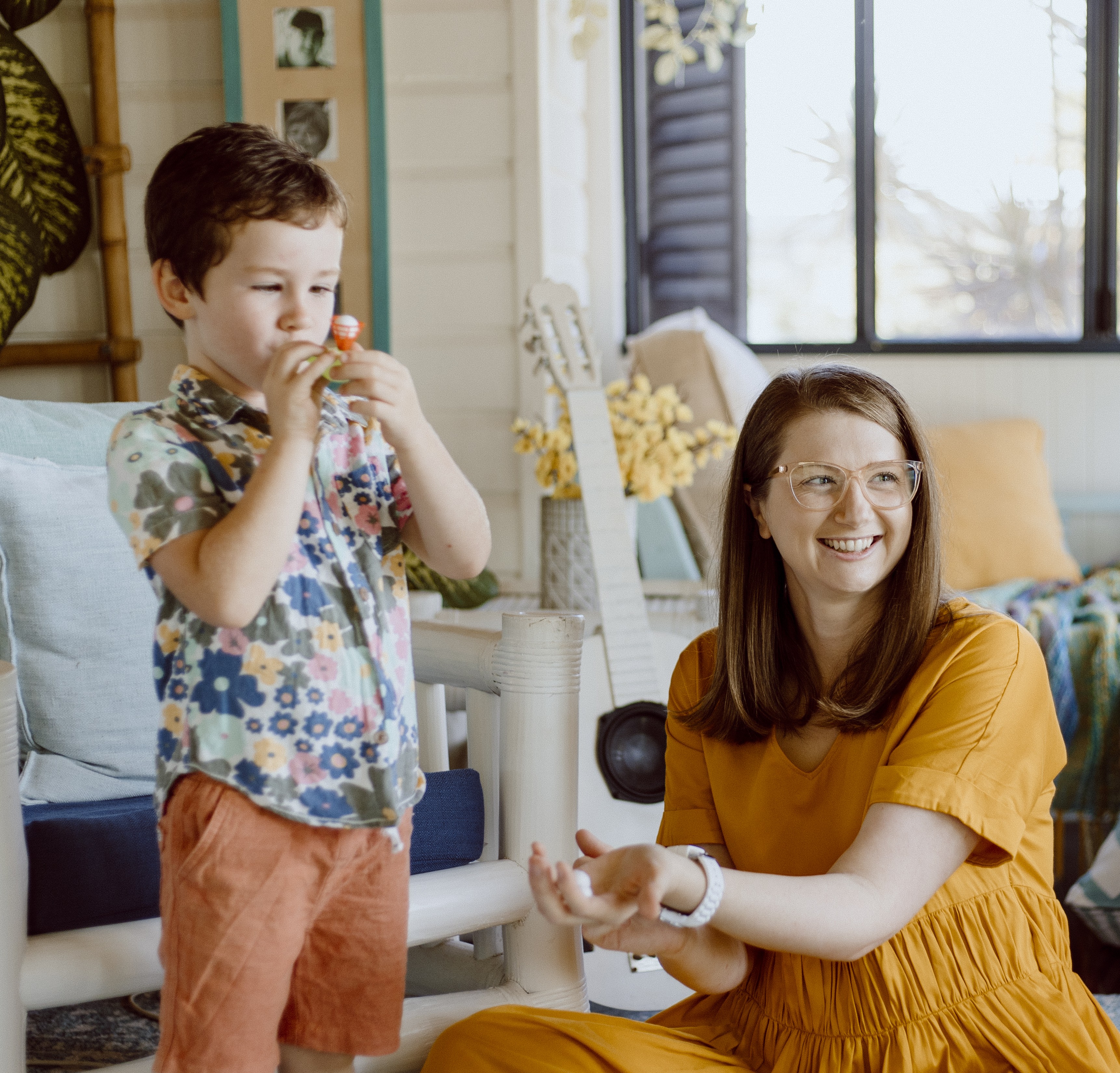A children’s oral health therapist engaging a young child with a puppet during an online oral health consultation.