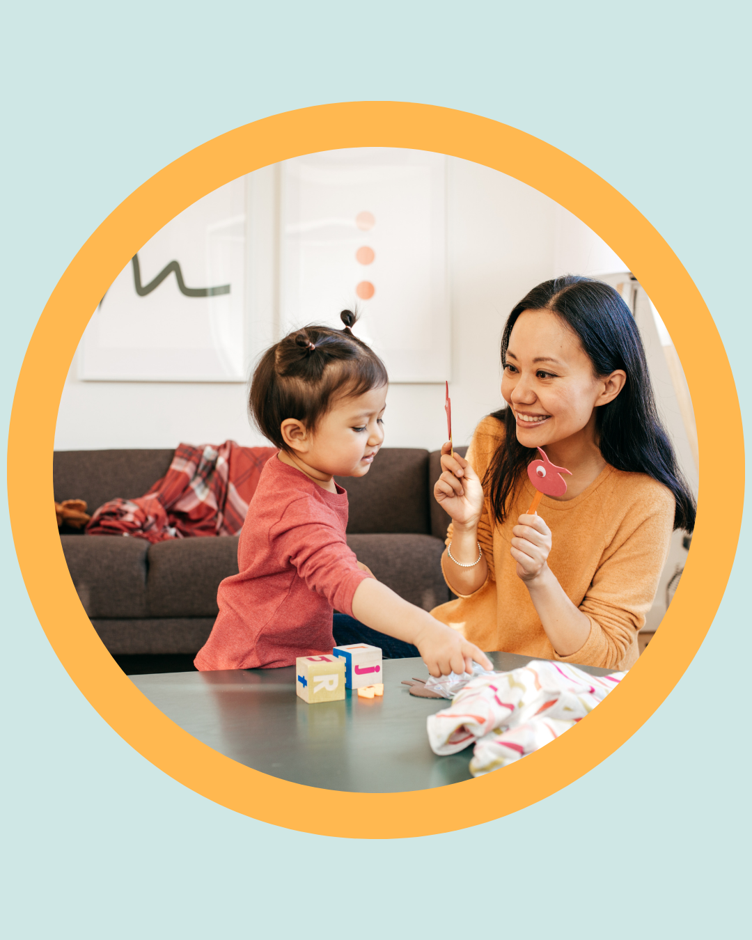 Parent and toddler playing together at home with toys and puppets, illustrating positive connection and early learning routines related to oral and developmental health.