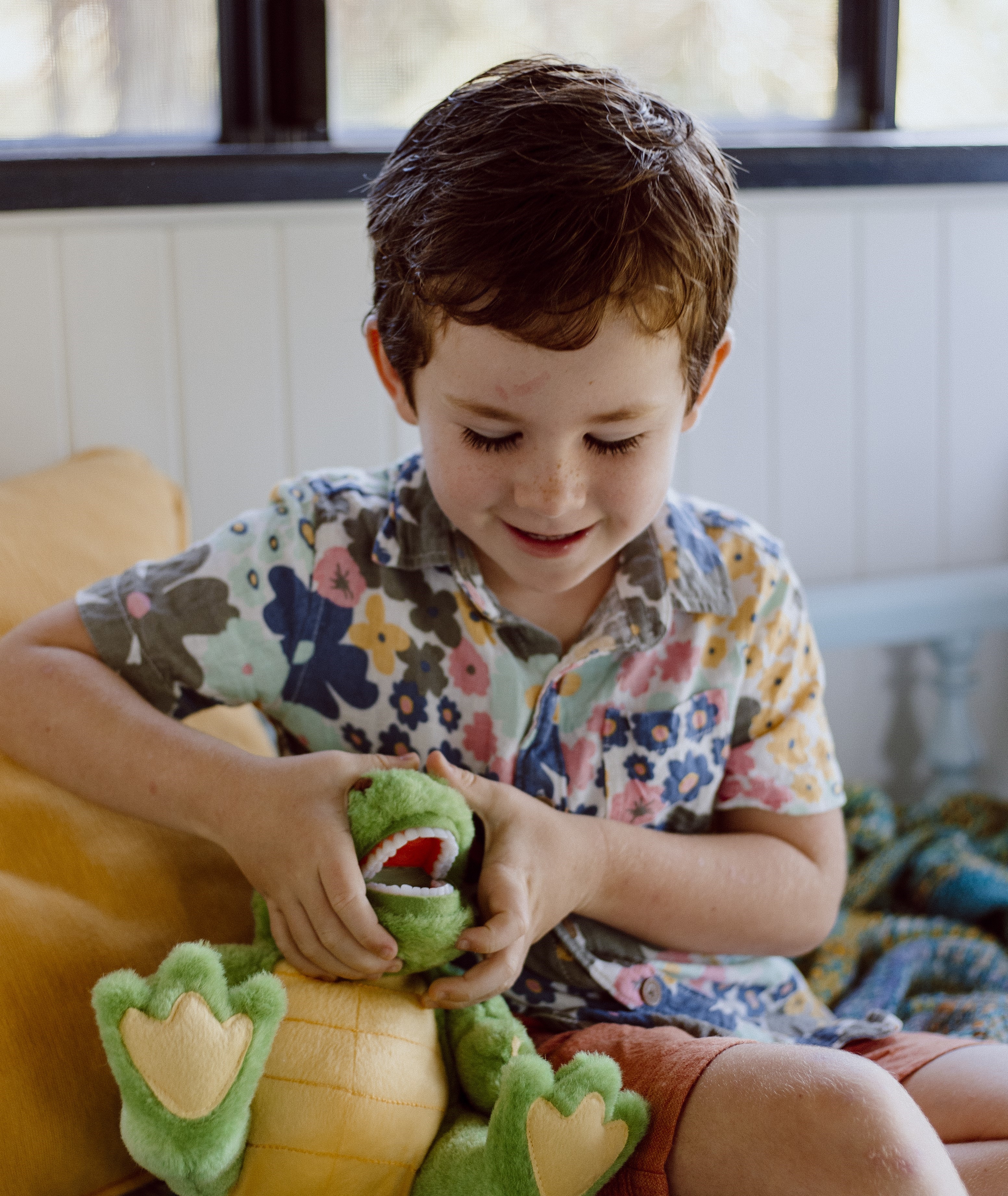 A children’s oral health therapist engaging a young child with a puppet during an online oral health consultation.
